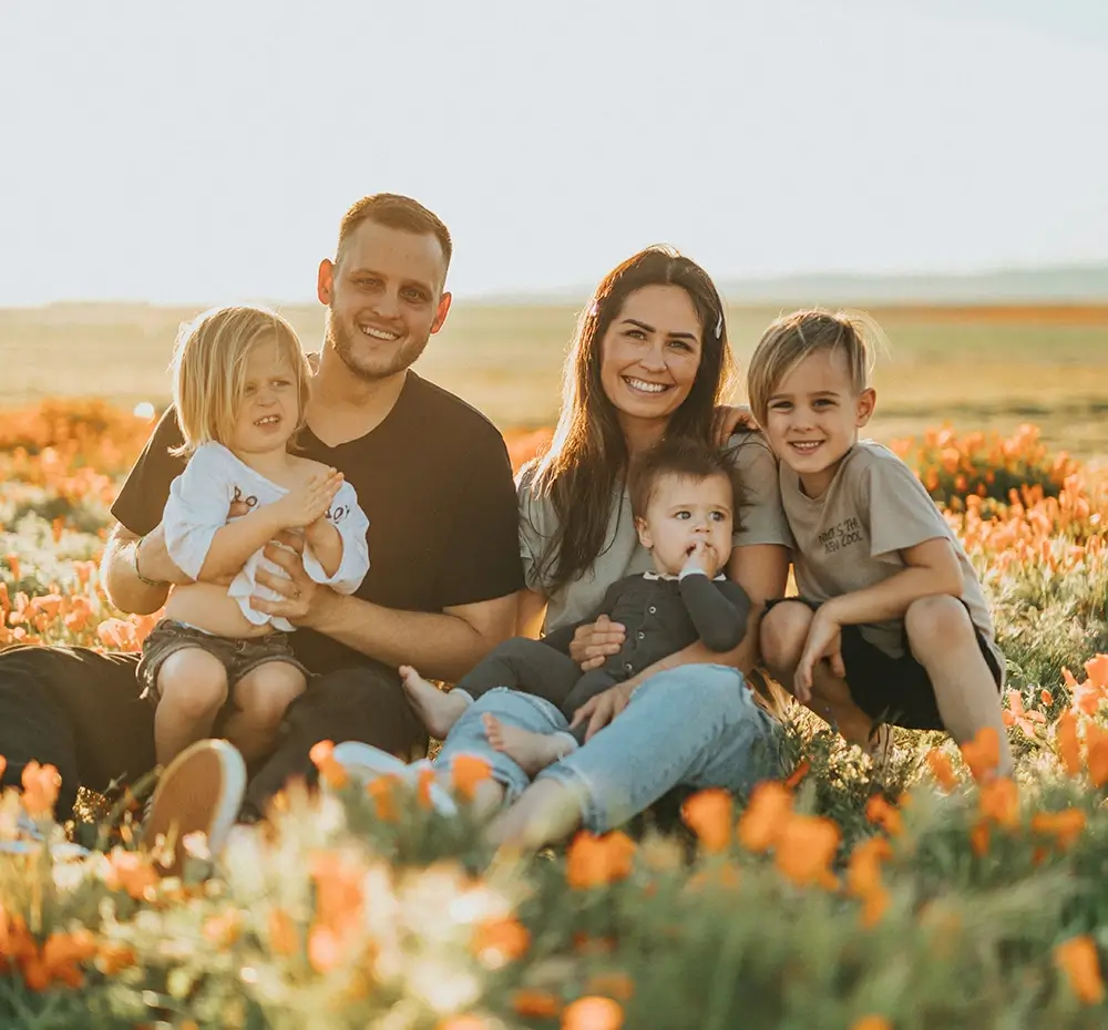 Family sitting in field of orange flowers