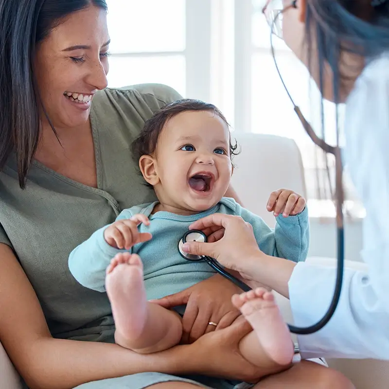 Mother holding baby during check-up